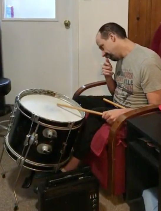 A 35 year old man named Ron playing drums using only 1 arm